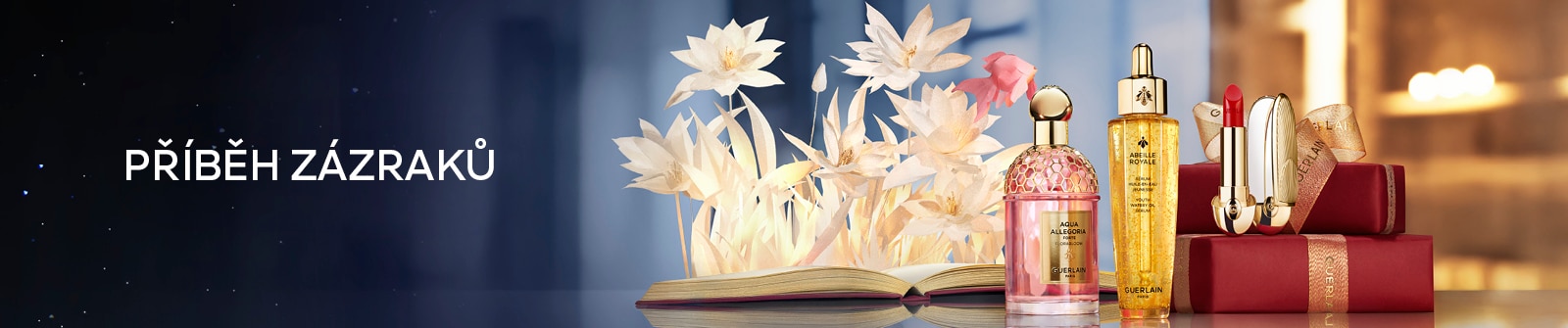 Luxusní kosmetika Guerlain – parfém Aqua Allegoria, sérum Abeille Royale a červená rtěnka na pozadí dárkových krabiček.